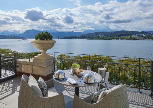 uma mesa numa varanda com vista para um lago em Mandarin Oriental Palace, Luzern em Lucerna