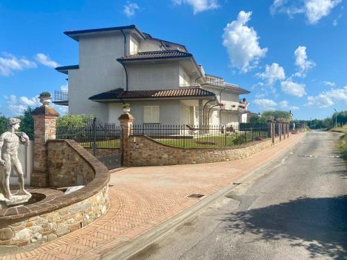 une grande maison blanche avec une clôture et une rue dans l'établissement -Casa Vacanza Il Glicine- Immerso Nel Verde, à Altopascio