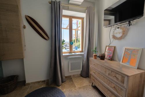 une chambre avec une commode et une fenêtre dans l'établissement Le Cabanon - Les pieds dans l'eau - Calanques - Wifi, à Ensuès-la-Redonne