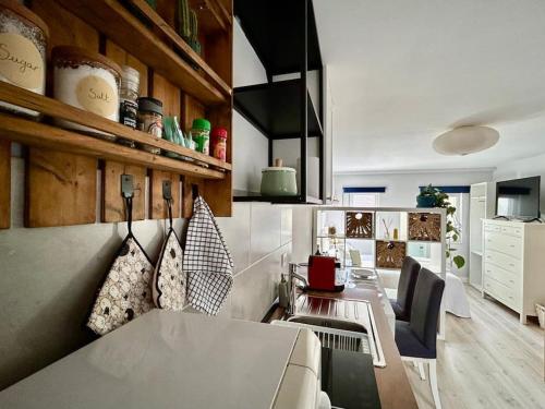 eine Küche mit einem langen Tisch und Stühlen in einem Zimmer in der Unterkunft Charmoso estúdio perto da praia in Parede