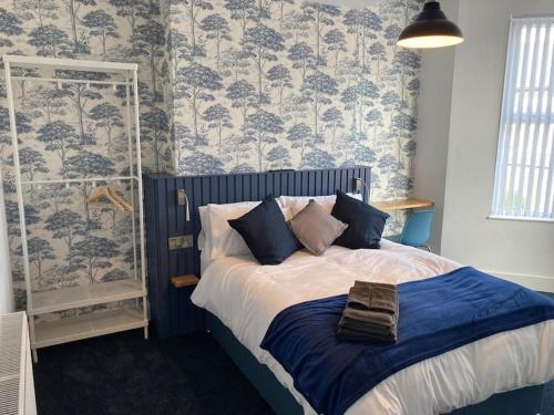 a bedroom with a bed with blue and white wallpaper at Exceptional 5 bed house near City Centre in Liverpool
