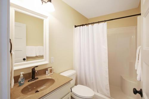 a bathroom with a sink and a toilet and a mirror at Red Anchor in Ottawa