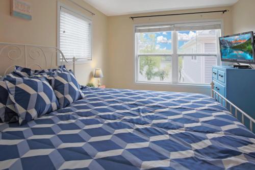 a blue and white bed in a bedroom with a television at Red Anchor in Ottawa