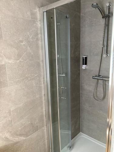 a bathroom with a shower with a glass door at Exceptional 5 bed house near City Centre in Liverpool