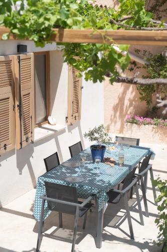 une table et des chaises bleues sur une terrasse dans l'établissement Le Cabanon - Les pieds dans l'eau - Calanques - Wifi, à Ensuès-la-Redonne
