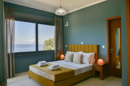 a bedroom with a bed with a large window at Dalasvillas SkalaAcqua in Skala Kefalonias