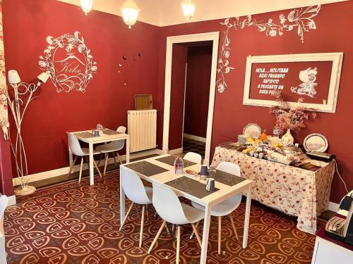 jadalnia z 2 stołami i krzesłami oraz czerwonymi ścianami w obiekcie B&B Kike w Katanii