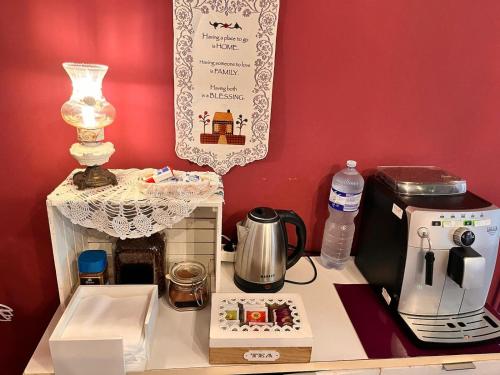 a kitchen counter with a coffee maker and a tea kettle at B&B Kike in Catania