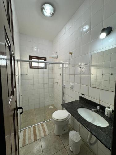 a bathroom with a toilet and a sink at Bangalô 6 praia de Guaratiba prado BA in Prado