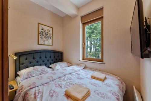 a bedroom with a bed with two towels on it at Zlatibor Centar Lux Apartman in Zlatibor