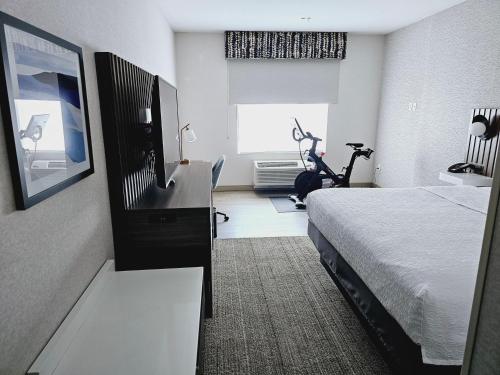 a hotel room with a bed and a treadmill at Hampton Inn Stockton, Ca in Stockton