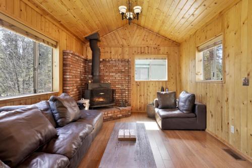 een woonkamer met een bank en een open haard bij 2259-Fawnskin Pines cabin in Fawnskin