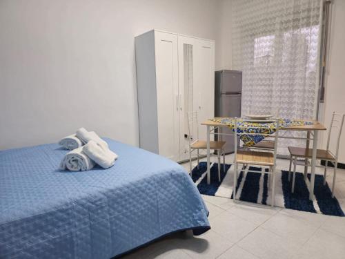 a bedroom with a blue bed and a table at Destinazione Mare Naxos in Giardini Naxos