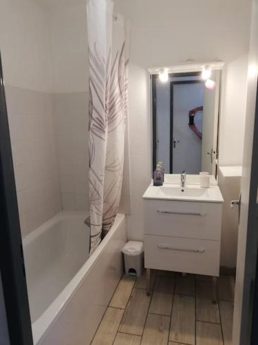 une salle de bain blanche avec un lavabo, une baignoire et des toilettes dans l'établissement Vacances au bord de l'eau, à Hourtin