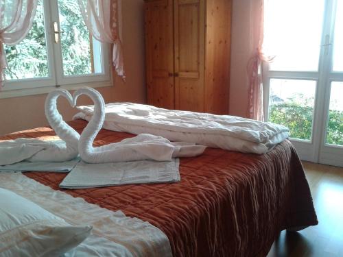 2 asciugamani a cigno sono sopra un letto di B&B I Baloss a Berbenno