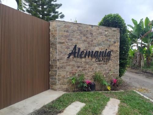 a brick wall with a sign for aulum clinic at Chalet La Alemania in Calarcá