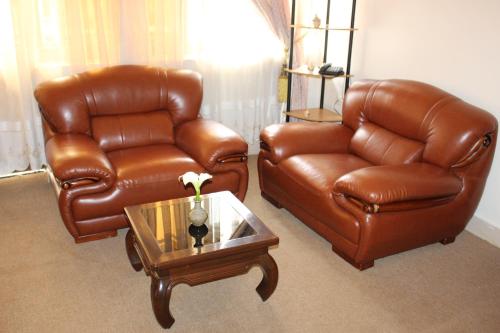 two leather chairs and a coffee table in a living room at Virunga Hotel in Ruhengeri