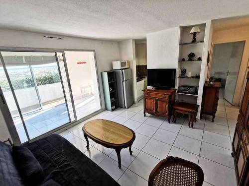 un salon avec un canapé et une table dans l'établissement Résidence Les Aigues Marines - Appartement 3 pièces pour 7 personnes avec Wifi face à la mer à Port Leucate en rez de chaussée. réf: 1AM_102 MAE-5854, à Port-Leucate