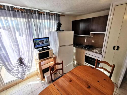 une petite cuisine avec une table et un réfrigérateur dans l'établissement Résidence Maryland 1 Et 2 - 3 Pièces 6 couchages PORT LEUCATE. Réf: 1MRL_24 MAE-5664, à Port-Leucate