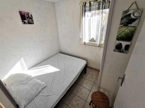 une petite chambre avec un lit blanc et une fenêtre dans l'établissement Résidence Maryland 1 Et 2 - 3 Pièces 6 couchages PORT LEUCATE. Réf: 1MRL_24 MAE-5664, à Port-Leucate