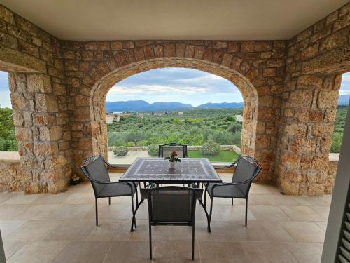 a dining room with an archway and a table and chairs at Villa Athina in Gythio
