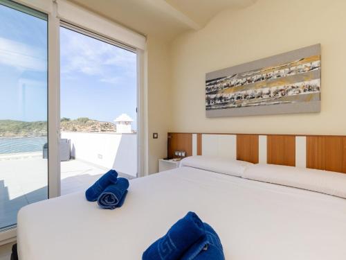 een slaapkamer met 2 bedden en een groot raam bij Roques5 - Adults Only - House In Es Grau in Es Grau