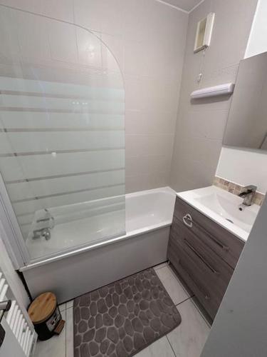 une salle de bain blanche avec une douche et un lavabo dans l'établissement Appartement chelles, à Chelles