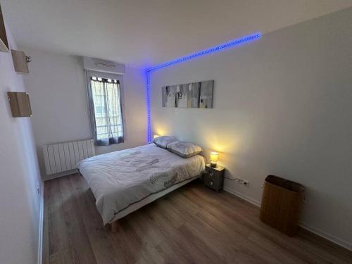 - une chambre dotée d'un lit avec une lumière bleue dans l'établissement Appartement chelles, à Chelles