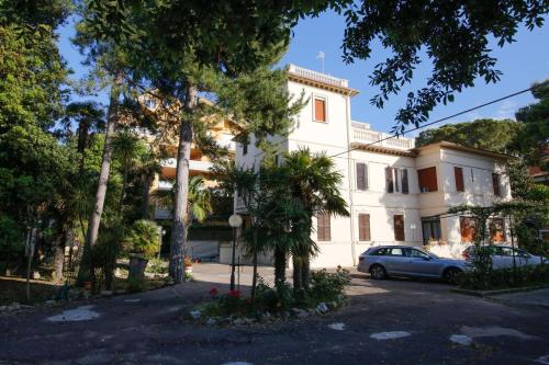 un edificio blanco con un coche aparcado delante de él en Hotel VILLA PINA, en Senigallia