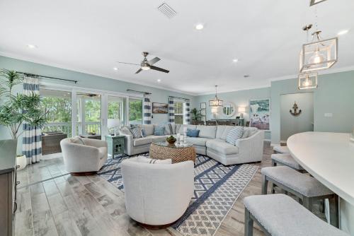 a living room with white furniture and a kitchen at Carlinga Cottage at Lost Key Golf & Beach Club in Pensacola