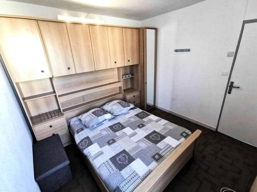 - une petite chambre avec un lit et des placards en bois dans l'établissement Résidence Le Village Grec - Villa 4 pièces, 6 personnes, Port Leucate MAE-6744, à Port-Leucate