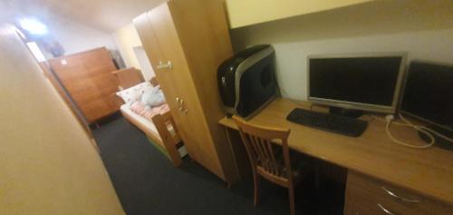 a desk with a computer monitor and a keyboard at Lhotka Kopeček in Žďár nad Sázavou