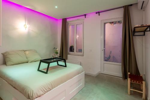 a bedroom with a bed with a table on it at Les nuits d’Ina in Toulon