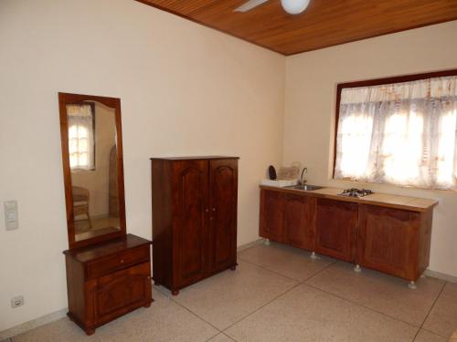 a bathroom with a sink and a mirror and a wooden cabinet at Mallika Guest House in Hikkaduwa