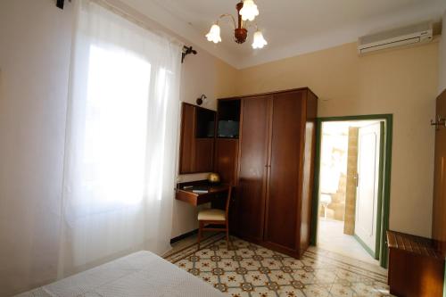 1 dormitorio con cama, escritorio y ventana en Hotel VILLA PINA, en Senigallia