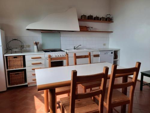 y cocina con mesa, sillas y fogones. en Casa Birtukan en Massino Visconti
