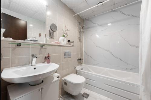 Great Gatsby's Home في دبي: حمام مع حوض ومرحاض وحوض استحمام