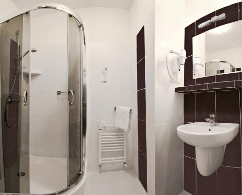 łazienka z przeszkloną kabiną prysznicową i umywalką w obiekcie Hotel Vitalia w Boszkowie