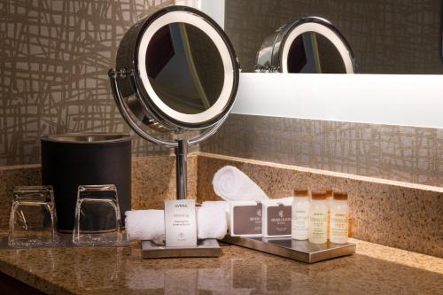 a bathroom counter with a mirror and towels and cosmetics at Silver Cloud Hotel - Seattle Lake Union in Seattle