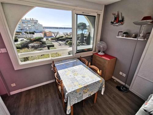 une salle à manger avec une table et une grande fenêtre dans l'établissement Résidence Terrasses De La Mediterranee 3 - APPT T2 4 couchages PORT LEUCATE MAE-7604, à Port-Leucate
