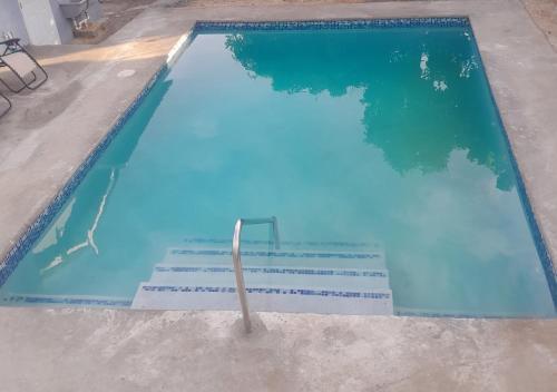 a swimming pool with blue water and stairs in it at Oak Villa Montego Bay 2 in Montego Bay