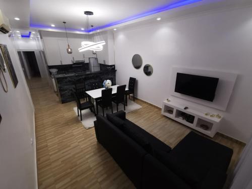 a living room with a black couch and a table with chairs at RESIDENCIAL IADI in Salinas da Samba