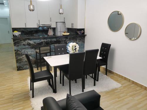 a dining room with a table and black chairs at RESIDENCIAL IADI in Salinas da Samba
