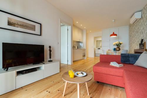 a living room with a red couch and a flat screen tv at Belem Design Apartments by Homing in Lisbon