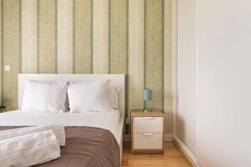 a bedroom with a bed and a side table with a lamp at Belem Design Apartments by Homing in Lisbon
