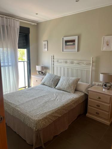 a bedroom with a large bed and a window at MET Apto en Las Dunas, Oliva Nova in Oliva