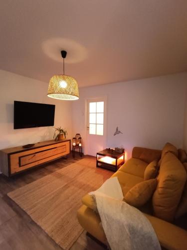 un salon avec un canapé et une télévision à écran plat dans l'établissement Urban Retreat, classé 3 étoiles, à Ebersheim