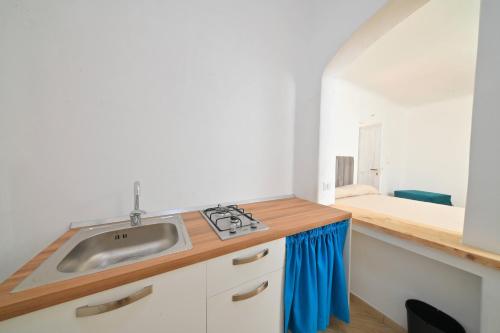 een kleine keuken met een wastafel en een bed bij Villa Aida in Ischia