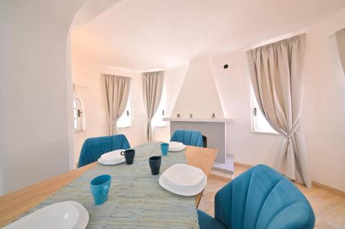 a dining room with a table and blue chairs at Villa Aida Luxury Apartments & Spa in Forio d'Ischia