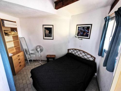 une chambre avec un lit noir dans une pièce dans l'établissement Résidence Copacabana - Bel appartement deux pièces à Port Leucate. Réf: 1COP_518E MAE-8924, à Leucate